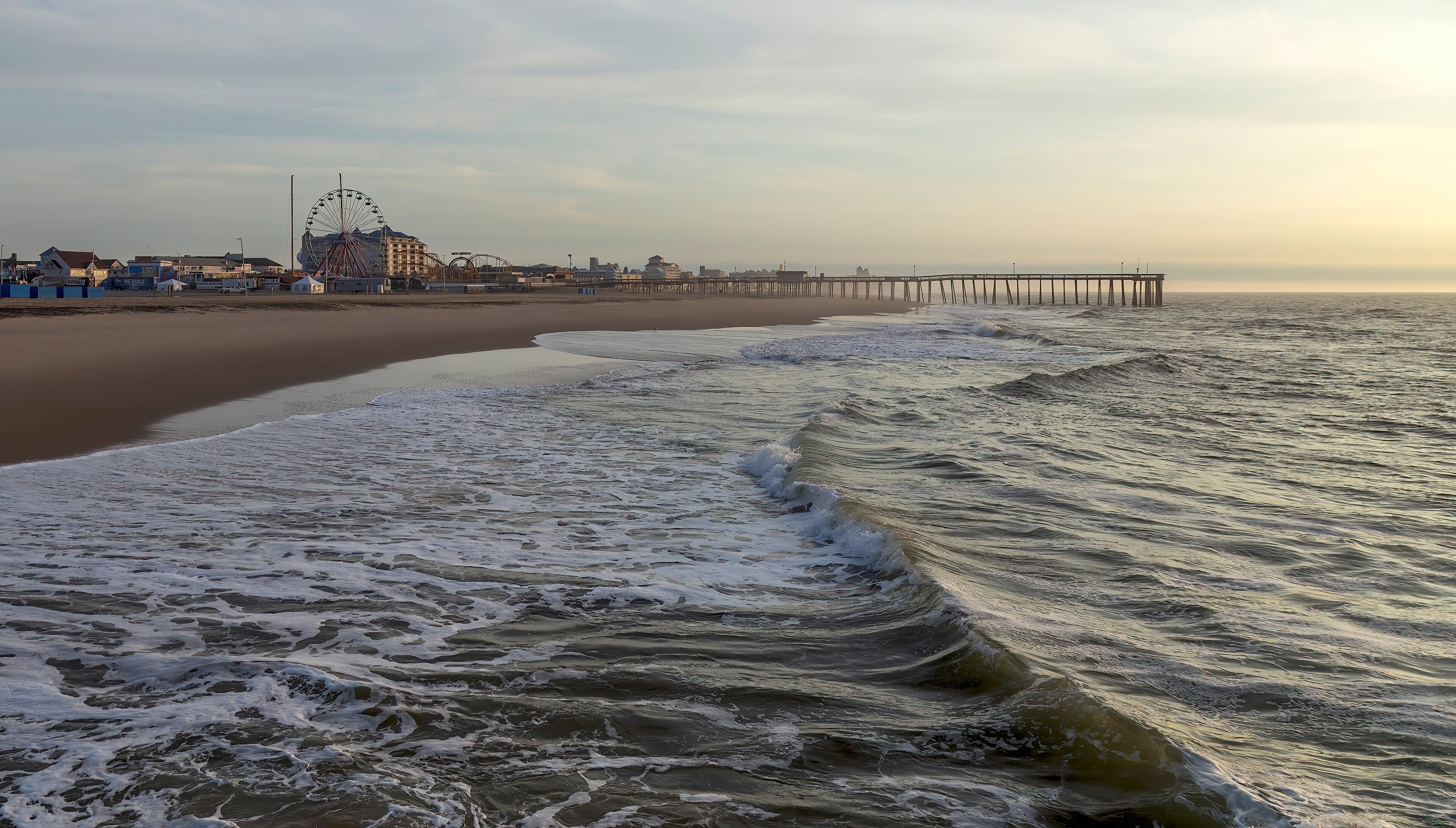 Daybreak over the Atlantic seen from Ocean City's jetty, with waves reflecting the orange sky.